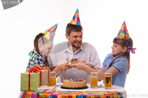 Image of Dad and two daughters fight for the first piece of the holiday cake