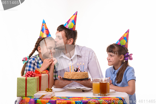 Image of Children wish dad happy birthday, father kisses daughter