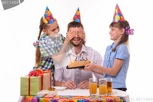 Image of Children give a sweet surprise to dad at a birthday party