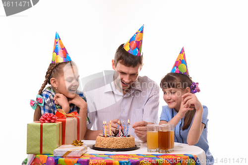 Image of Dad lights candles on a birthday cake