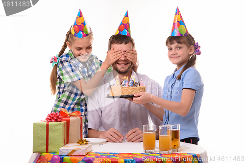 Image of The children closed their eyes to dad and prepared a surprise for him in the form of a cake with candles