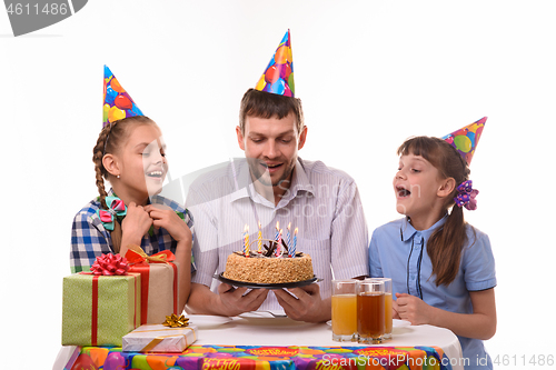 Image of Dad and two daughters took a little more air to blow out the candles on the holiday cake