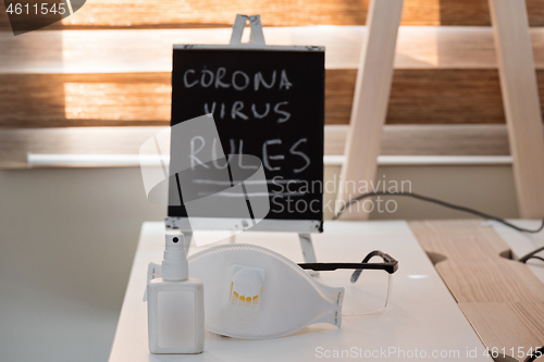 Image of Conceptual photo with miniature blackboard, protecting mask and antiseptic. Stay home concept