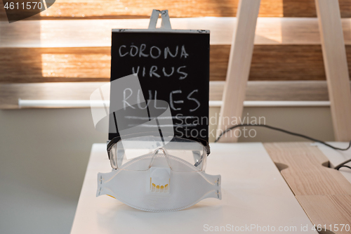 Image of Conceptual photo with miniature blackboard, protecting mask. Stay home concept