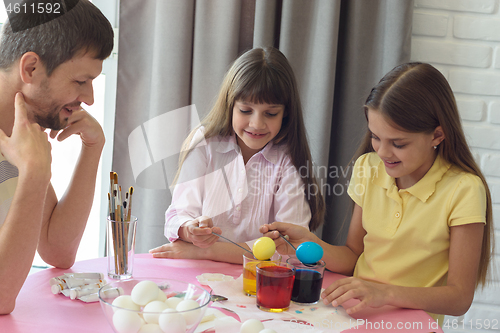 Image of Children painted the first Easter eggs, dad watches them