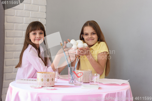 Image of Children hold a large plate with chicken eggs before coloring for Easter