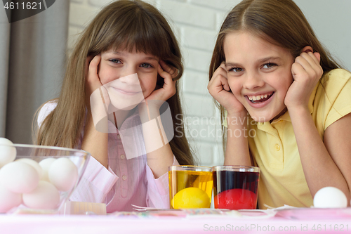 Image of Children wait until Easter eggs turn colored and have fun looking at the frame