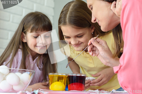 Image of Family fun watching how the eggs are painted in a solution with dyes