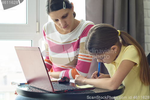 Image of Mom helps daughter do homework