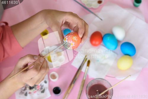 Image of Hand paints eggs for Easter holiday.