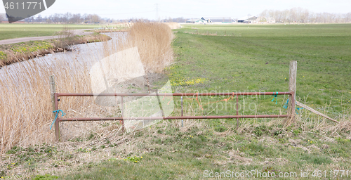 Image of Metal fence and farm gate leading into grassy field