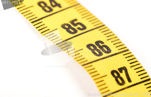 Image of Close-up of a yellow measuring tape isolated on white - 86