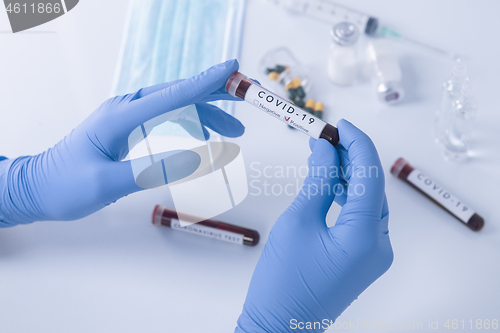 Image of Analyst hands with protective gloves holding COVID 19 Coronaviru