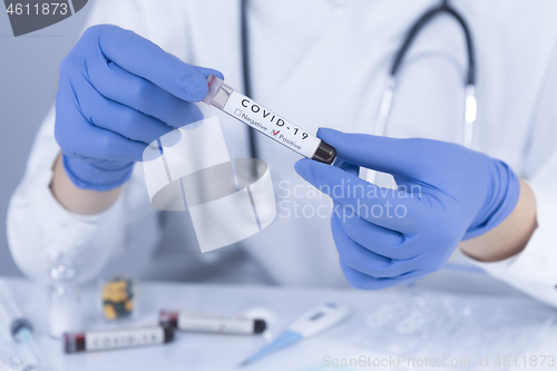 Image of Doctor hands holding COVID 19 Coronavirus test blood