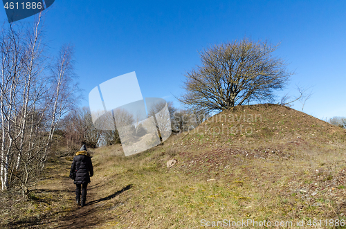 Image of Woman walks on a footpath in spring season