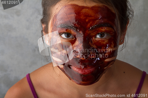 Image of young asian girl having fun with a chocolate mask