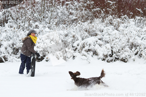 Image of Girl playing with her dog in the snow