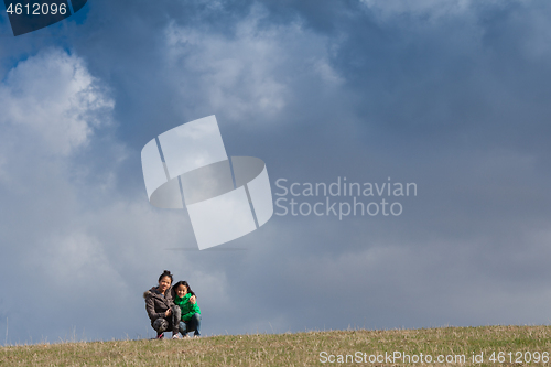 Image of Cute girl running jumping at the on a field in the summer