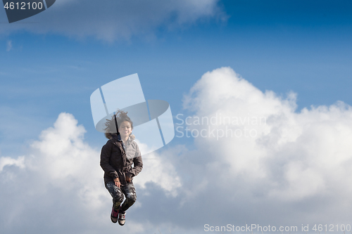 Image of Cute girl running jumping at the on a field in the summer