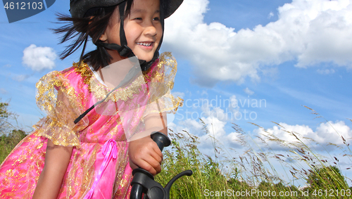 Image of Cute girl cycling with a princess outfit