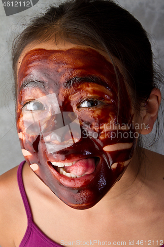 Image of young asian girl having fun with a chocolate mask