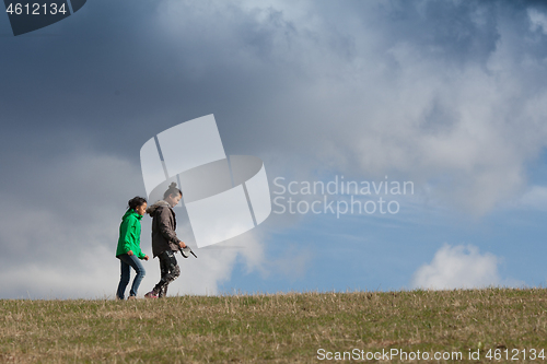 Image of Cute girl running jumping at the on a field in the summer