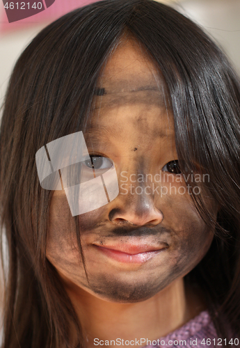 Image of Portrait of a young cute girl looking at the camera putting coal