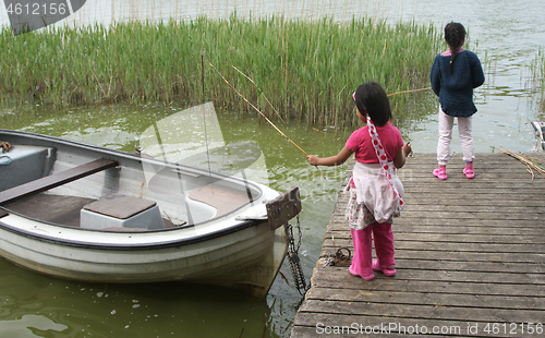 Image of Sisters palying in the nature with a boat