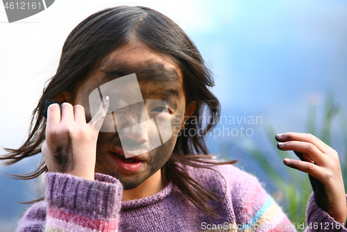 Image of Portrait of a young cute girl looking at the camera putting coal