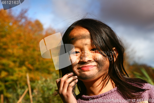 Image of Portrait of a young cute girl looking at the camera putting coal