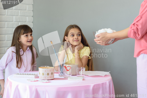 Image of Mom brought a large plate with eggs to the girls on the table, for their subsequent painting by Easter