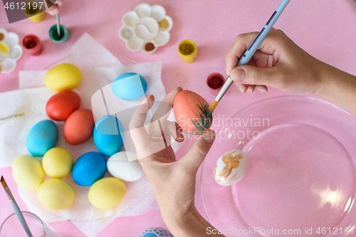 Image of Hand paints a chicken egg on Easter