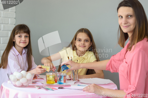 Image of Mom and two daughters put dye in glasses with water