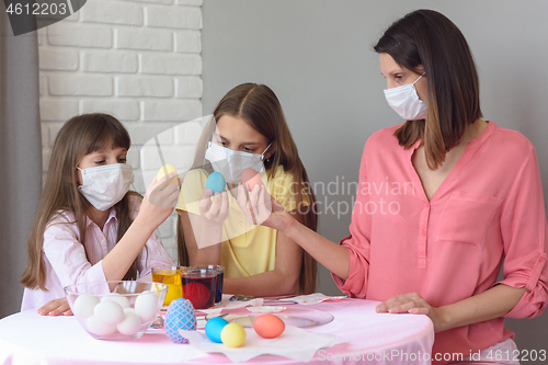 Image of Mom and two quarantined daughters painted eggs for Easter