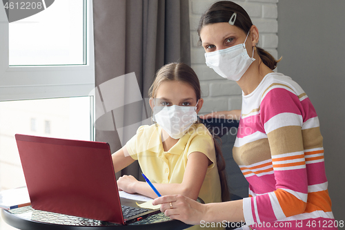 Image of Mom and daughter do their homework in self-isolation mode through online services