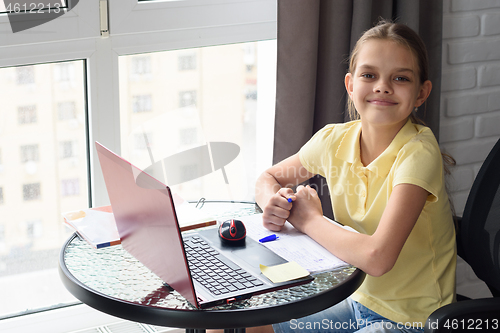 Image of Joyful girl did homework looked in frame