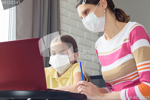 Image of Girl and tutor in medical masks study remotely online