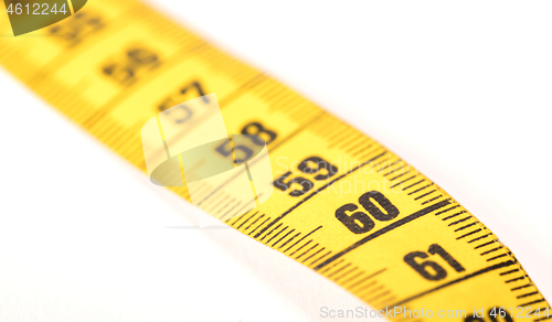 Image of Close-up of a yellow measuring tape isolated on white - 60