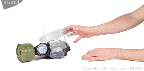 Image of Arm reaching for vintage gasmask isolated on white - Green filte