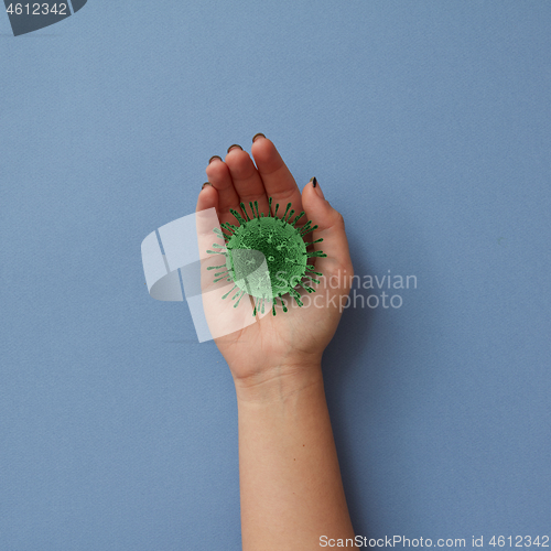 Image of Female hand with model of Coronavirus bacteria.