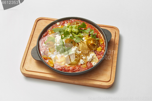 Image of Pan with homemade traditional Shakshuka dish with spicy sauce from tomatoes.