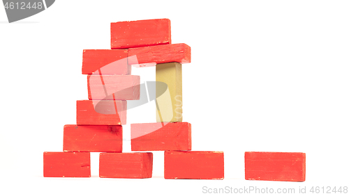 Image of Vintage red building blocks isolated on white, one standing out