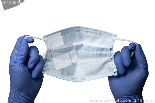 Image of Gloved hands holding a surgical mask