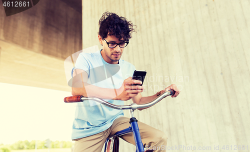 Image of man with smartphone and fixed gear bike on street