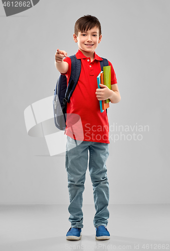 Image of student boy with books and bag pointing to you