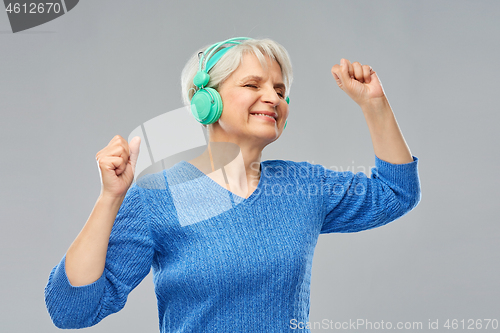 Image of senior woman in headphones listening to music