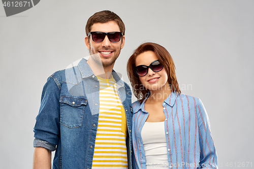 Image of happy couple in sunglasses over grey background