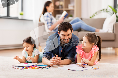 Image of father with little daughters drawing at home