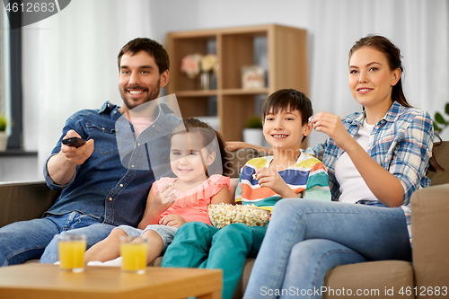 Image of happy family with popcorn watching tv at home