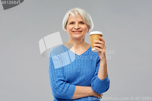 Image of smiling senior woman with takeaway coffee cup